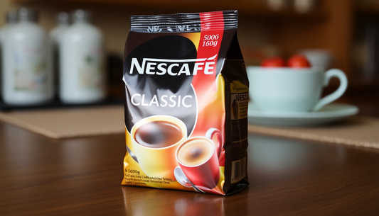 Nescafe Classic Coffee 500g Pack on wooden table with blurred background of coffee cup and kitchen items