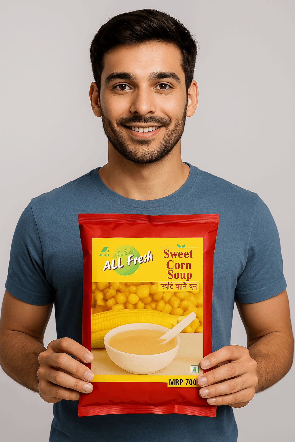 Man holding All Fresh Sweet Corn Soup premix pack in red and yellow packaging