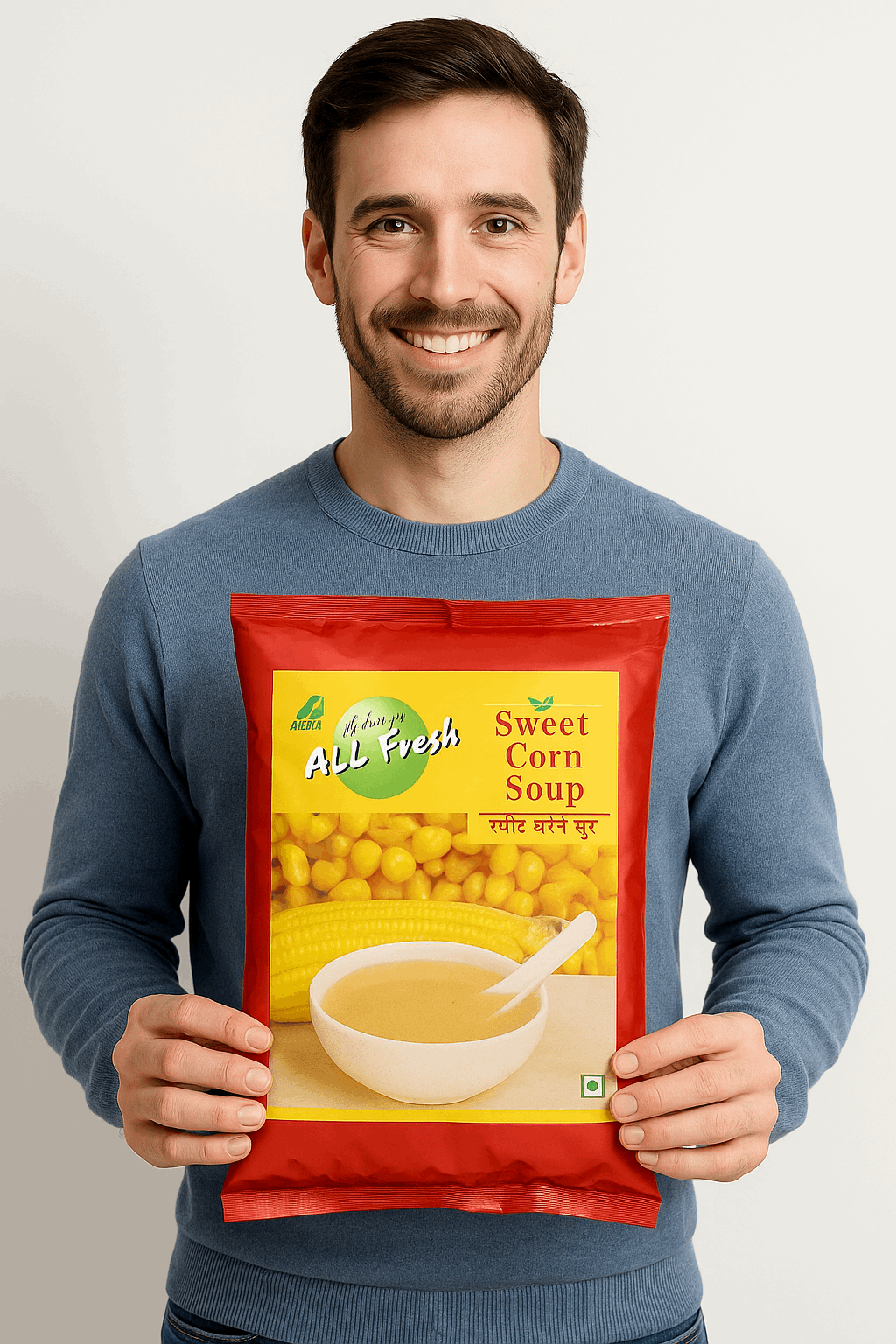 Man holding a red packet of sweet corn soup premix from Tea coffee vending service