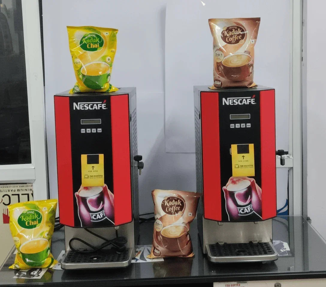 Two Nescafe coffee and tea vending machines with Kadak Coffee and Kadak Chai packets on a black table Amazon tea coffee machine Noida