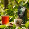 Automatic tea coffee vending machine maintenance with fresh brewed tea cup and coffee cup beside coffee beans