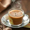 Steaming cup of tea in a glass with saucer, perfect for Atlantis Kadak Chai offers for offices