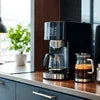 Modern coffee machine rental near me on kitchen counter with glass coffee pot and cup