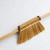 Traditional Indian cleaning broom with natural bristles and wooden handle for household use