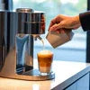 Commercial tea and coffee machines Delhi making fresh coffee with milk frother in modern kitchen