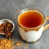 Nescafe Masala Gold Tea Premix price in Noida shown with spiced tea in a glass cup and masala ingredients