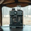 Commercial coffee vending machines for army camps placed on a wooden table with outdoor background