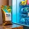 Amazon Plus tea premix 1kg for vending machines pack placed on counter near vending machine