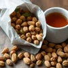 Atlantis cardamom tea price in Noida shown with cardamom pods and brewed tea cup