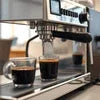 Commercial coffee machine brewing espresso shots with two cups on the drip tray for coffee machine rental in Sahibabad