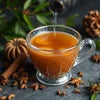 Indian cardamom tea powder benefits shown with a cup of hot spiced tea surrounded by cardamom and cinnamon