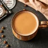Cup of chai tea with coffee beans nearby showcasing bulk chai powder suppliers in Delhi