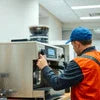 Technician performing ATLANTIS coffee machine installation guide steps on commercial coffee equipment