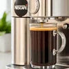 Nescafe coffee machine brewing black coffee with glass cup on kitchen counter showing Nescafe coffee machine price in India