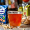 Nestea cardamom tea price in Noida with a glass of brewed tea and cardamom pods