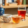 Nestea cardamom tea price wholesale shown with brewed tea in cups on a wooden table