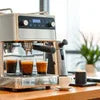 Commercial espresso machine brewing coffee with cups on counter explaining how to choose an office coffee machine
