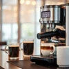 DeLonghi coffee machine brewing espresso with two cups for best office coffee machines in Delhi