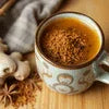 AMAZON Plus ginger tea premix benefits shown with a cup of ginger tea and fresh ginger on wooden surface