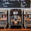 Commercial coffee machine types for cafes displaying three different espresso machines with cups and chalkboard menu