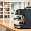 Black coffee machine supplier in Noida Sector 104 placed on wooden countertop in office setting