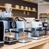 Coffee machine supplier showcasing premium espresso machines on wooden counter in modern cafe