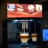 Atlantis Brew coffee vending machine price display with freshly brewed coffee cups under dispenser