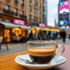 Close-up of a single cup of coffee on a saucer in a busy street cafe, coffee premix suppliers near me