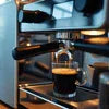 Espresso shot brewing from coffee machine in Ghaziabad with dark coffee pouring into glass