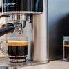 Atlantis Coffee Machine Noida brewing fresh espresso coffee in a clear glass cup