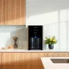 Atlantis coffee machine 2 option black model on wooden kitchen countertop with sunlight