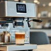 Atlantis Coffee Machine noida brewing fresh espresso with layered milk coffee in glass cup