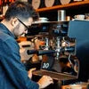 Technician performing coffee machine service Greater Noida on an espresso machine in a café setting