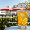 Refreshing glass of iced lemon tea on table with outdoor cafe background showcasing best dairy whitener in Noida