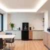 Office coffee machine Greater Noida setup in modern kitchen with wooden flooring and dining area