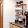 Best coffee vending machine for IT offices on countertop with shelves and coffee supplies in modern office kitchen