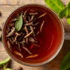 Close-up of a cup of brewed tea with herbs, not related to coffee machine rental in Ghaziabad