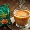 Coffee machine in Indirapuram Ghaziabad serving steaming hot kadak chai in a glass cup with tea premix packet