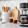 Coffee brewing setup with black coffee maker and glass cups for vending machine installation Ghaziabad