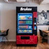 Brukes branded vending machine with assorted beverages in a cozy cafe setting for coffee machine AMC service Ghaziabad