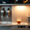 Automatic coffee machine dispensing hot COFFEE PREMIX into a glass cup