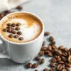 Cafe Desire Strong Coffee Premix cup with coffee beans on a light surface