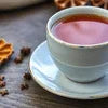 top tea premix for offices Delhi served in a white cup on a saucer with coffee beans and spices nearby