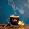 Cafe Desire Mocha Coffee Premix steaming cup with coffee beans and chocolate on blue background