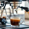 Espresso shot being brewed from a coffee machine Delhi in a clear glass cup