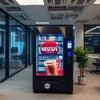 Atlantis tea coffee vending machine inside modern office lounge with glass walls and plants