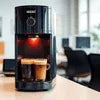 Atlantis coffee premix brewing fresh coffee from coffee machine on wooden table