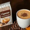 Atlantis tea premix cappuccino variant with coffee beans and a cup of frothy cappuccino
