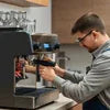 Technician performing coffee machine service Sector 102 on espresso machine in cafe setting