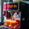 Atlantis cafe machine price in Indirapuram showing fresh juice dispenser with two glasses filled